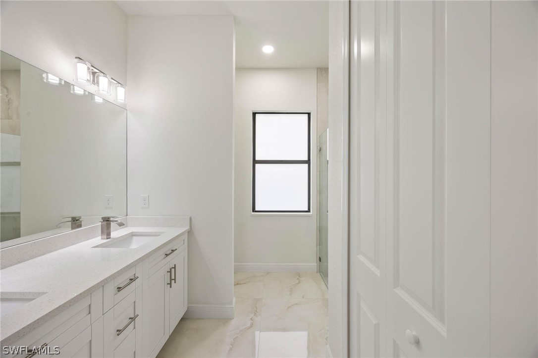 2909 37th Street Southwest Lehigh Acres, FL 33976 - Photo 24 of 29 a bathroom with a double vanity sink and a mirror