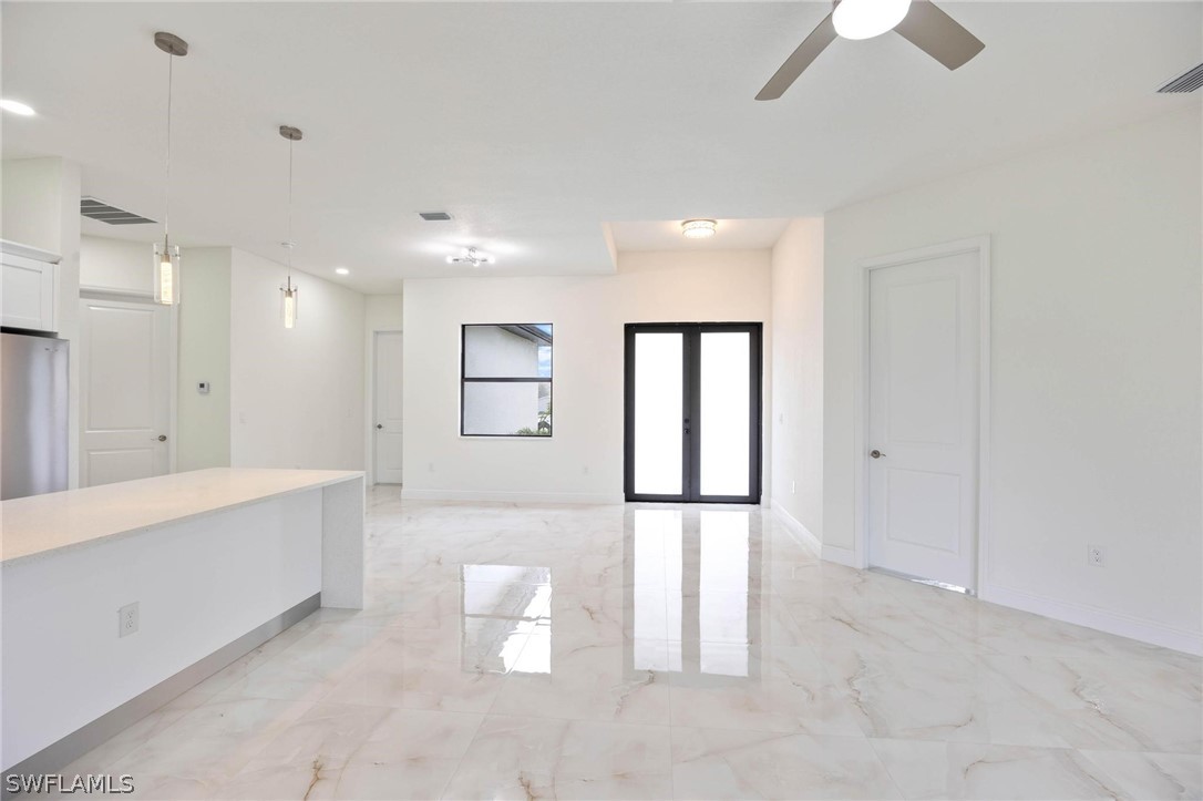 2909 37th Street Southwest Lehigh Acres, FL 33976 - Photo 7 of 29 a view of a big room with windows and chandelier fan