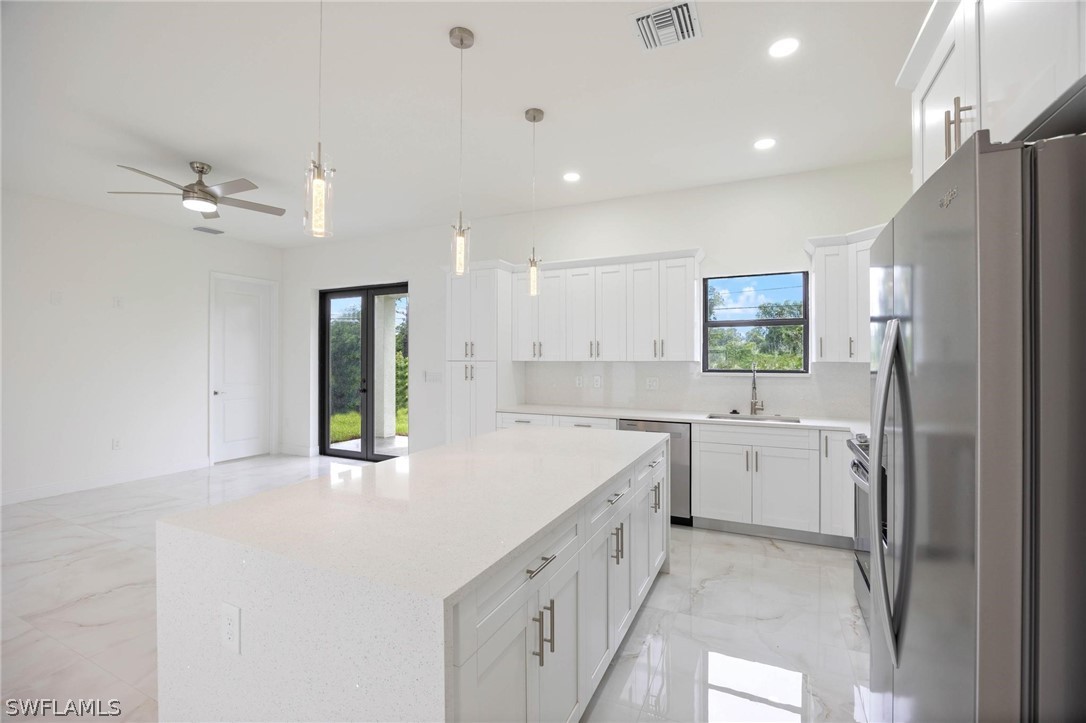 2909 37th Street Southwest Lehigh Acres, FL 33976 - Photo 8 of 29 a large white kitchen with a refrigerator a stove a sink and a window