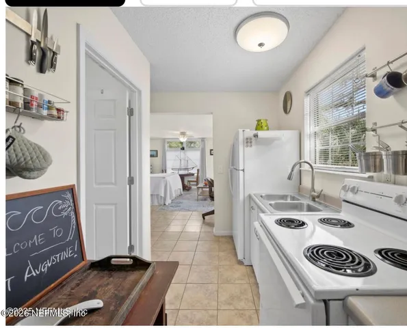 a kitchen with a refrigerator a stove a sink and a stove with wooden floor