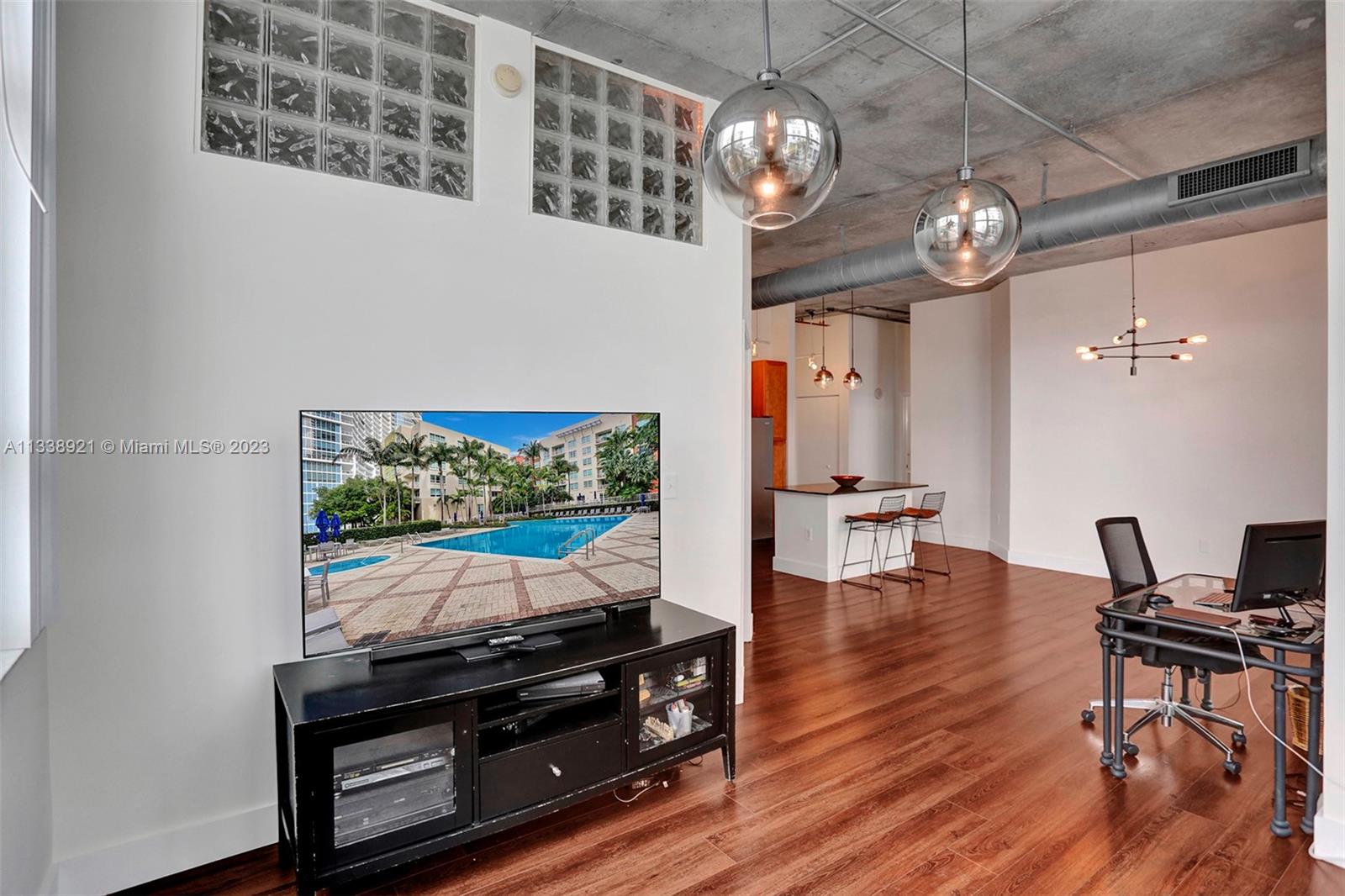 2001 Biscayne Boulevard, Unit 2202 Miami, FL 33137 - Photo 4 of 31 a view of a dining room with furniture a chandelier and wooden floor