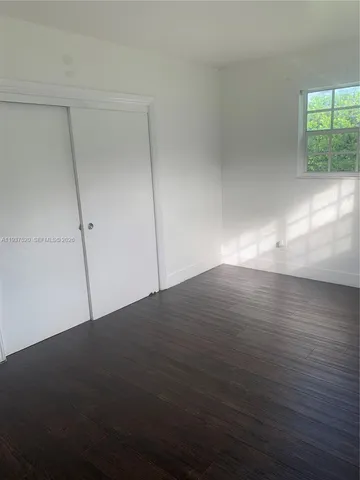 an empty room with wooden floor and door