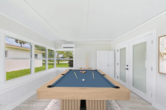 a room with pool table and windows