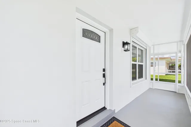 a view of a hallway with wooden floor and windows