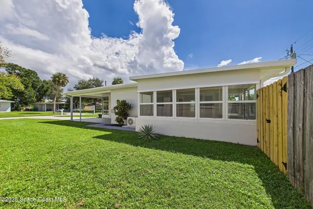 a view of house with backyard space and balcony