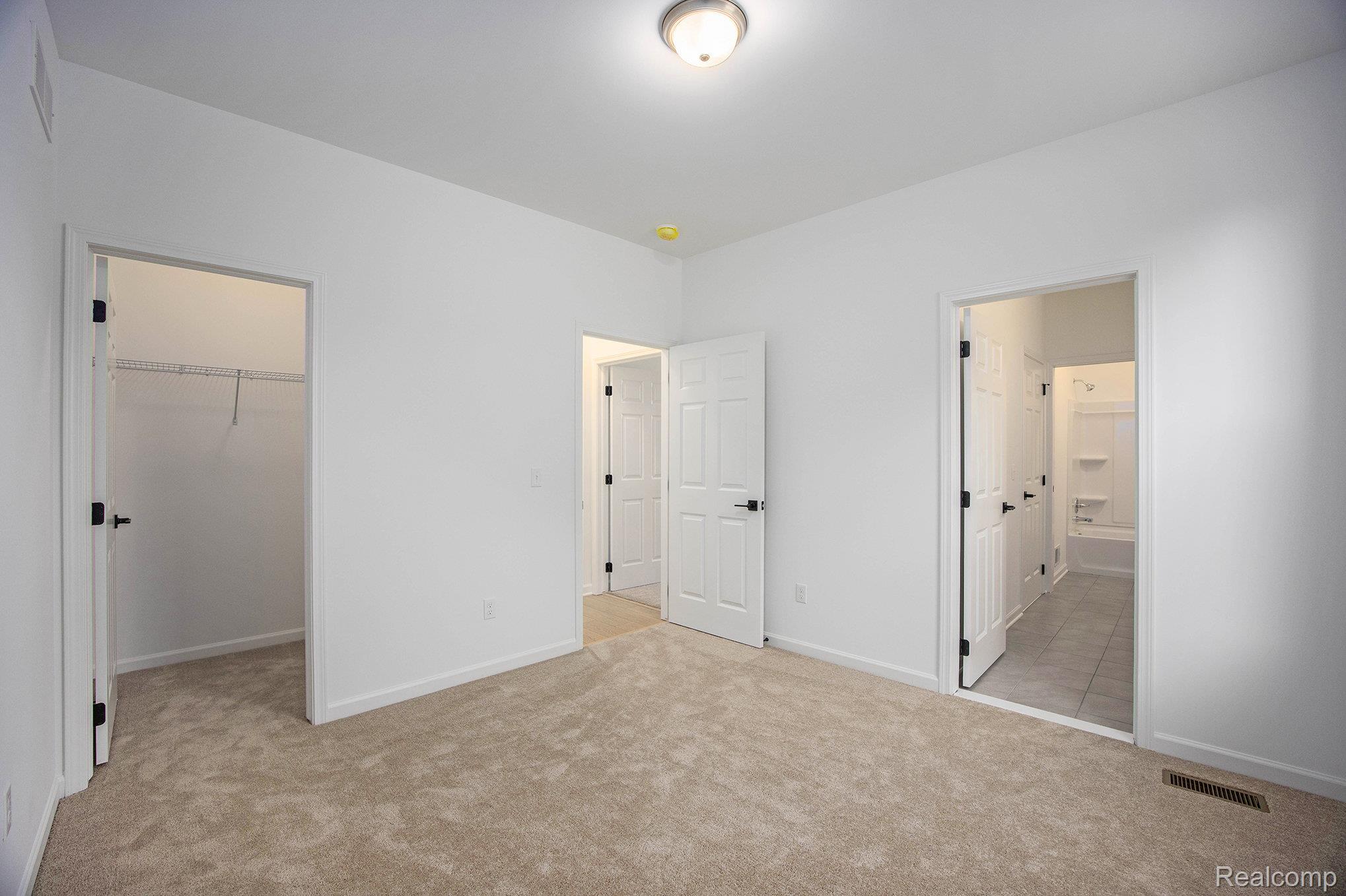 68788 Place Road New Haven, MI 48050 - Photo 9 of 29 Unfurnished bedroom with a walk in closet, light carpet, and ensuite bath