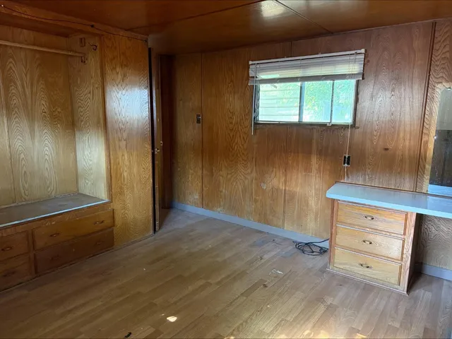 a view of a closet area with wooden floor