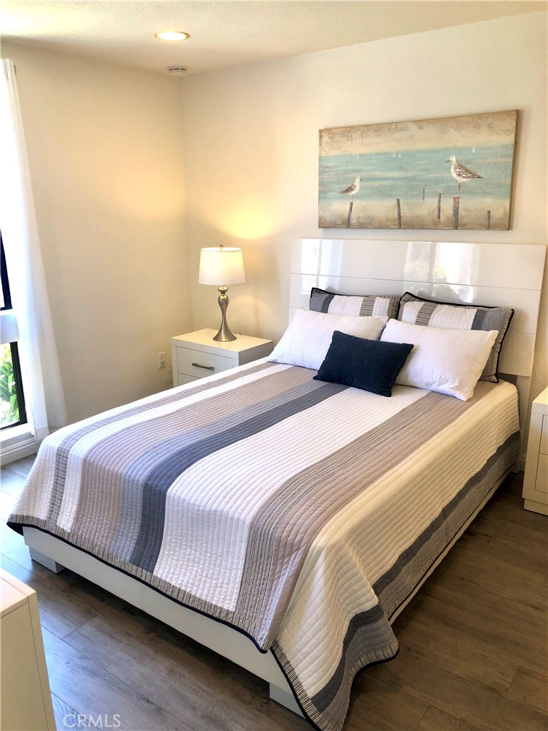 24339 Pasto Road, Unit A Dana Point, CA 92629 - Photo 19 of 28 a bedroom with a bed and wooden floor