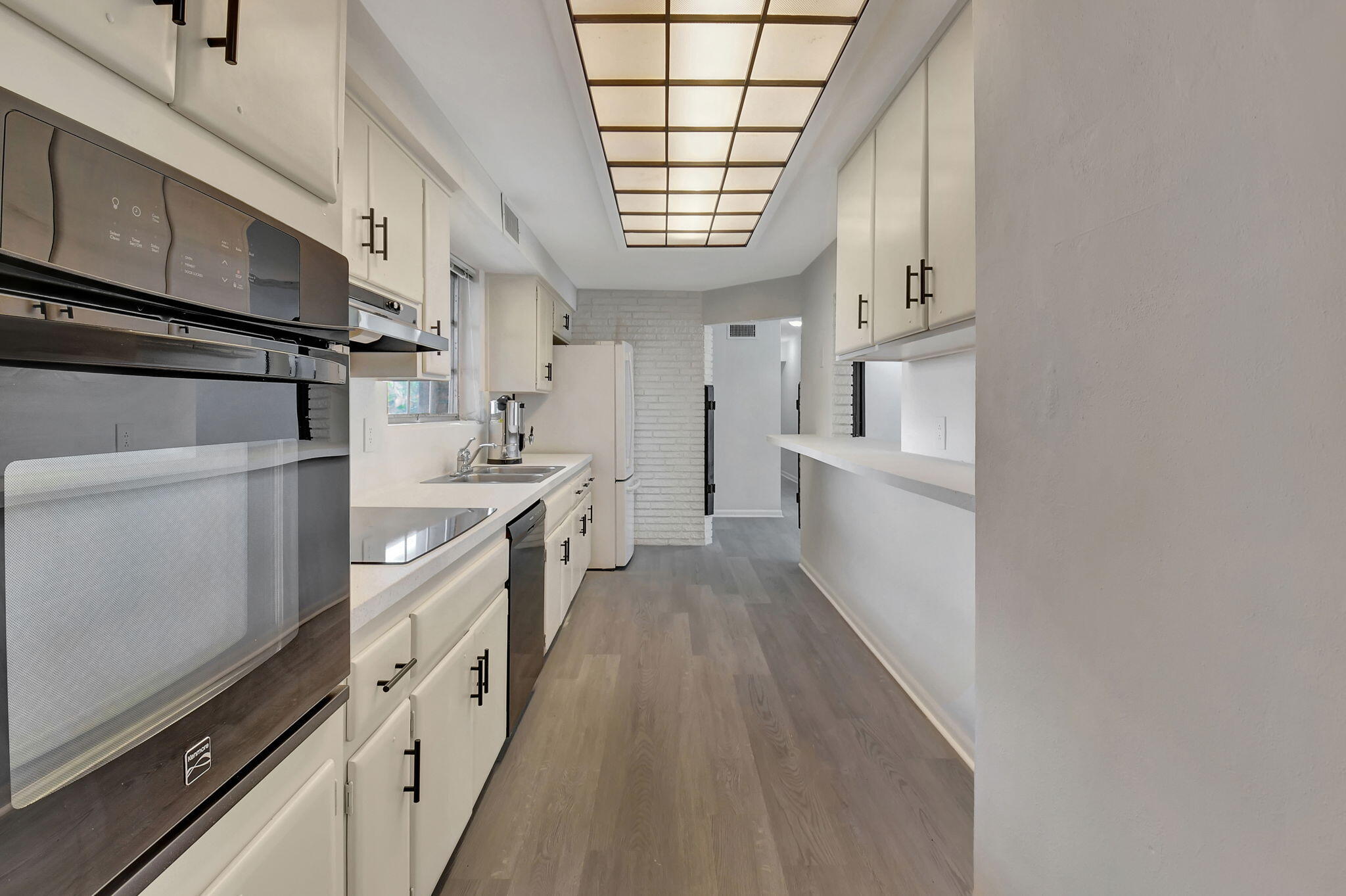 410 Spanish River Boulevard Boca Raton, FL 33431 - Photo 9 of 26 a kitchen with stainless steel appliances a sink window and cabinets