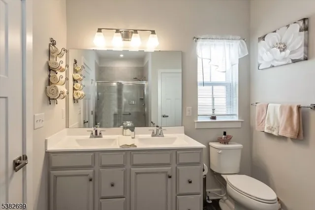 a bathroom with a sink mirror and a toilet