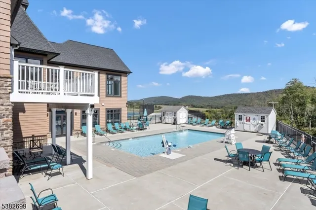 a view of a house with pool and chairs