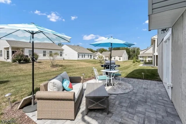 a view of a patio with couches table and chairs under an umbrella