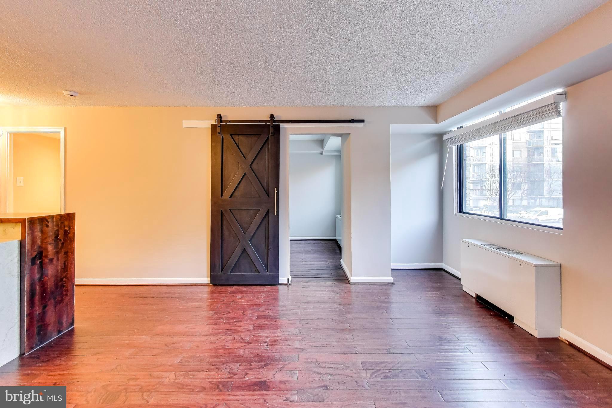 1245 13th Street Northwest, Unit 208 Washington, DC 20005 - Photo 10 of 19 a view of an empty room with wooden floor and a window
