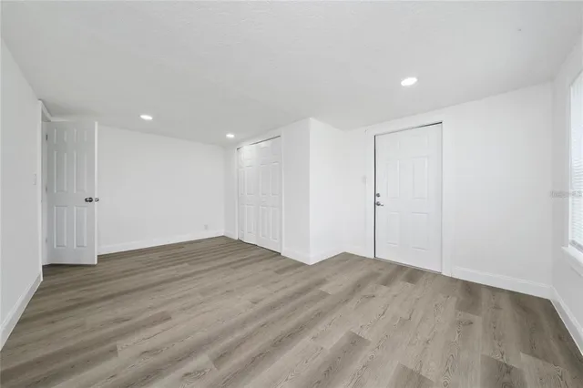 a view of an empty room with wooden floor
