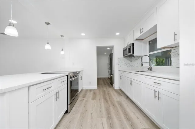a large white kitchen with cabinets