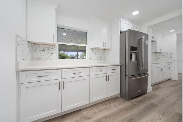 a kitchen with stainless steel appliances a refrigerator sink and cabinets