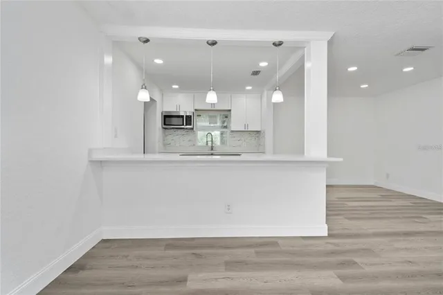 a view of kitchen with granite countertop cabinets and a wooden floor