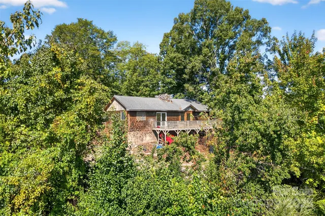 a small barn with a big yard and large trees