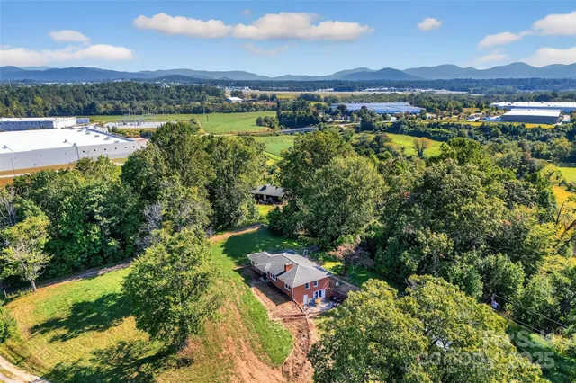 an aerial view of residential houses with outdoor space and lake view