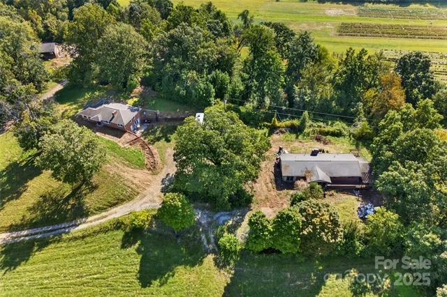 a aerial view of a house with a yard lake and outdoor seating