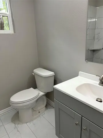 a white toilet sitting next to a bathroom sink