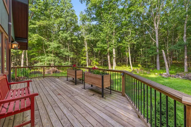 a view of a deck with wooden floor and fence next to a yard
