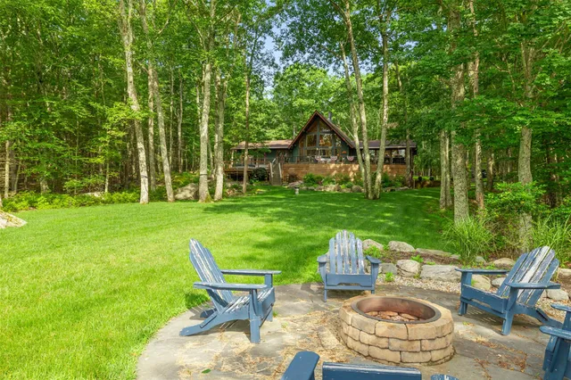 a view of a chair and table in backyard of the house