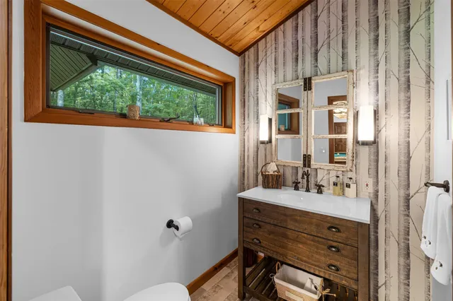 a bathroom with a sink mirror and a window