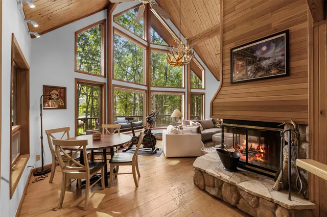 a dining room with furniture a fireplace and large window