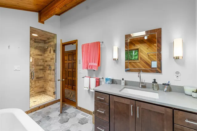 a bathroom with a sink vanity granite tub shower and a mirror
