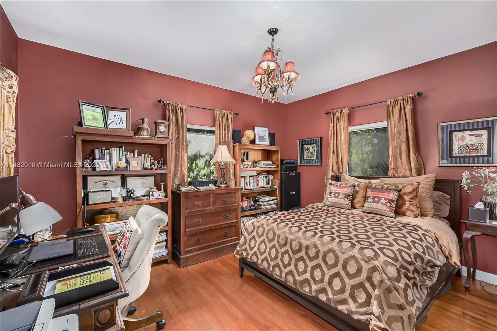 28 Southwest 26th Road Miami, FL 33129 - Photo 22 of 38 a bedroom with a bed a bookshelf and a chandelier