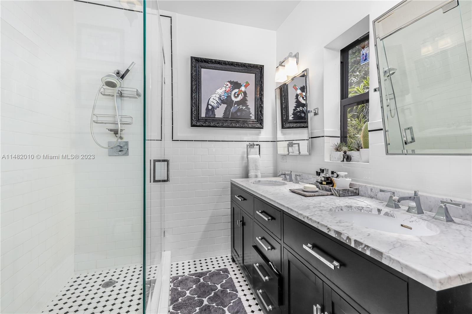 28 Southwest 26th Road Miami, FL 33129 - Photo 25 of 38 a bathroom with a granite countertop sink a mirror and a shower