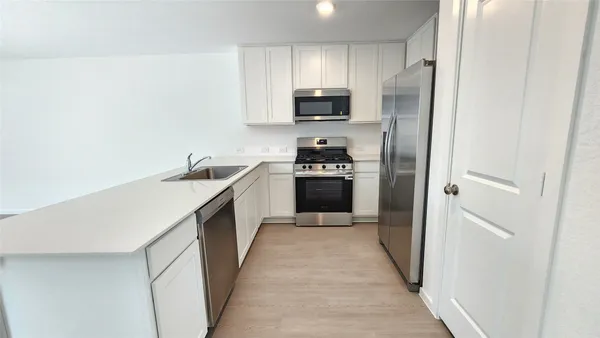 a view of a kitchen with a sink and a large window