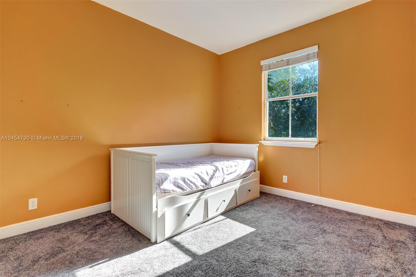 2127 Southwest 99th Way Miramar, FL 33025 - Photo 29 of 43 a bed sitting in a room next to a blue wall