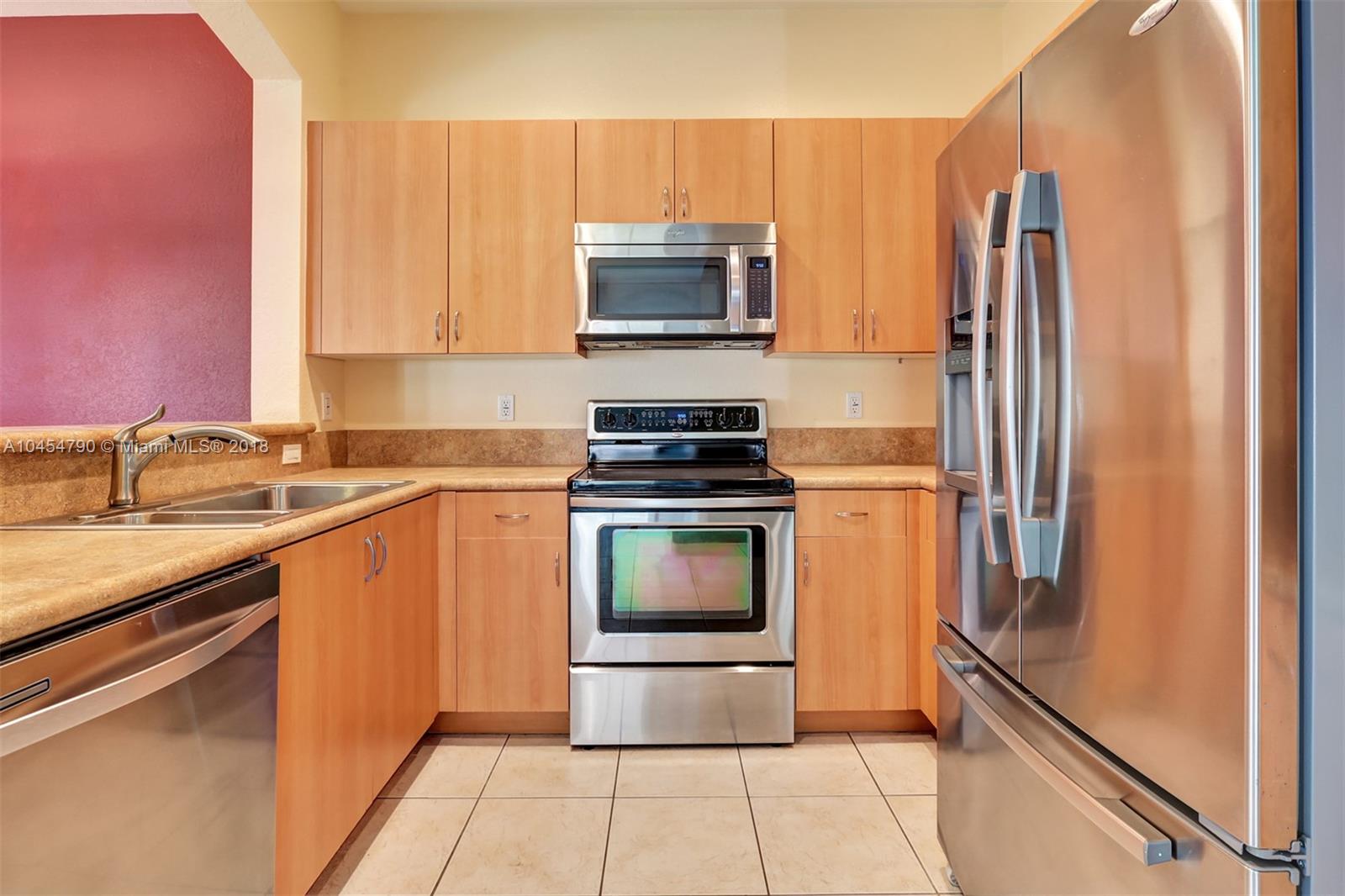 2127 Southwest 99th Way Miramar, FL 33025 - Photo 7 of 43 a kitchen with stainless steel appliances a stove microwave and sink