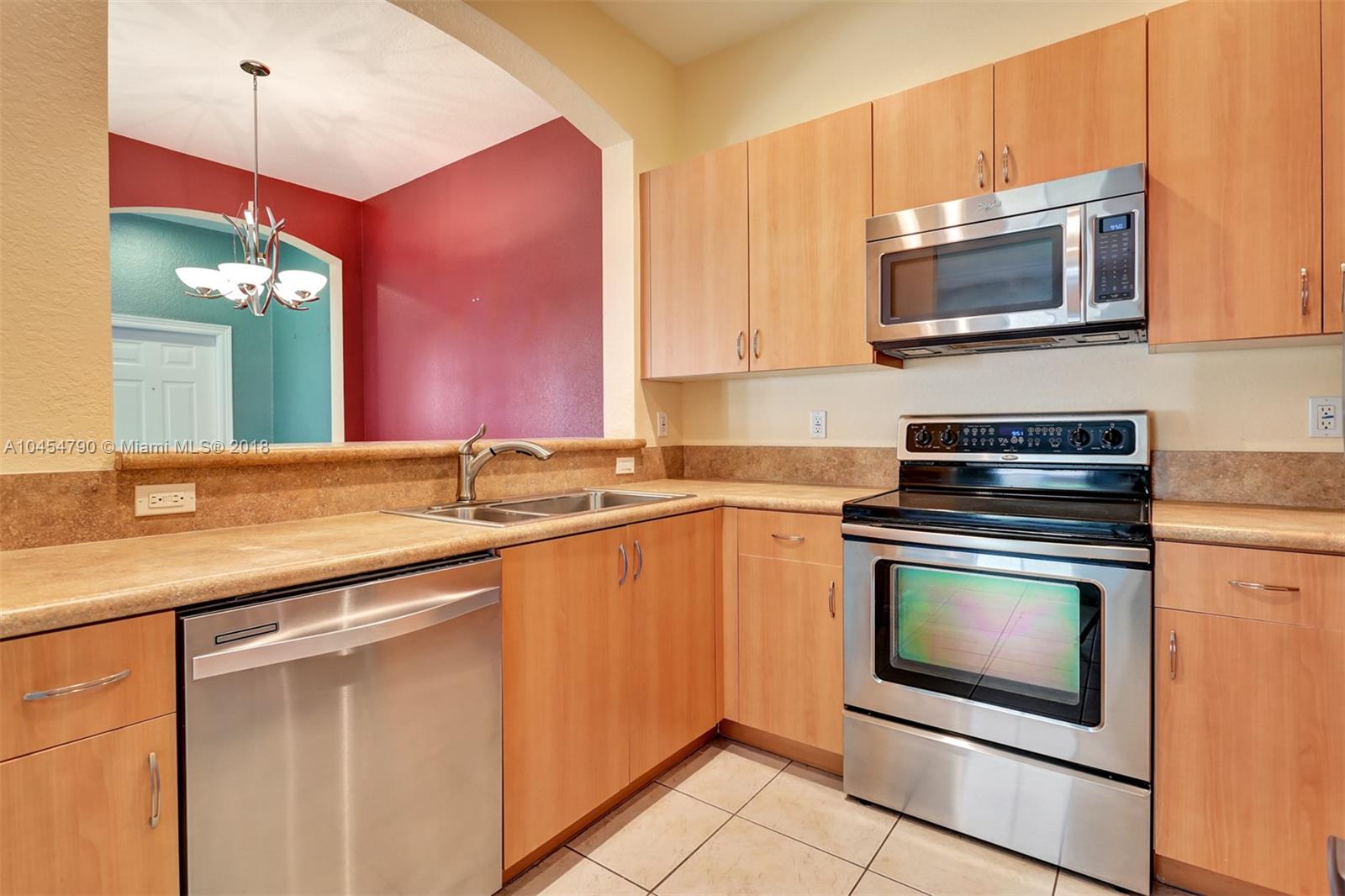 2127 Southwest 99th Way Miramar, FL 33025 - Photo 8 of 43 a kitchen with granite countertop a stove a sink and a microwave