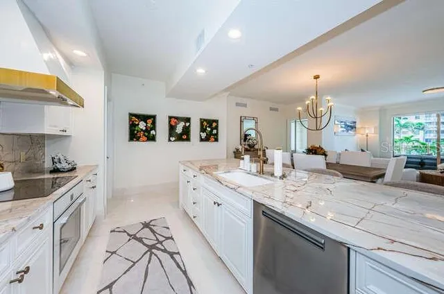 a kitchen with granite countertop a sink stainless steel appliances and cabinets