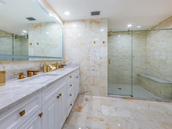 a bathroom with a tub sink shower and mirror
