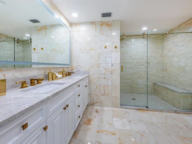 a bathroom with a tub sink shower and mirror