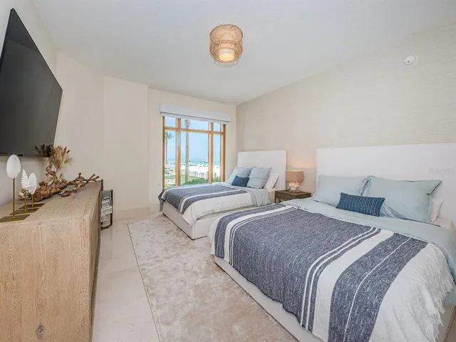 a bedroom with two beds and a flat screen tv