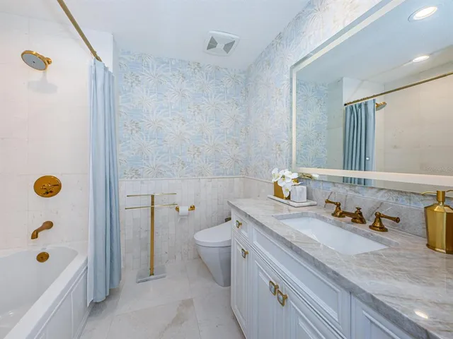 a bathroom with a sink a mirror a toilet and shower