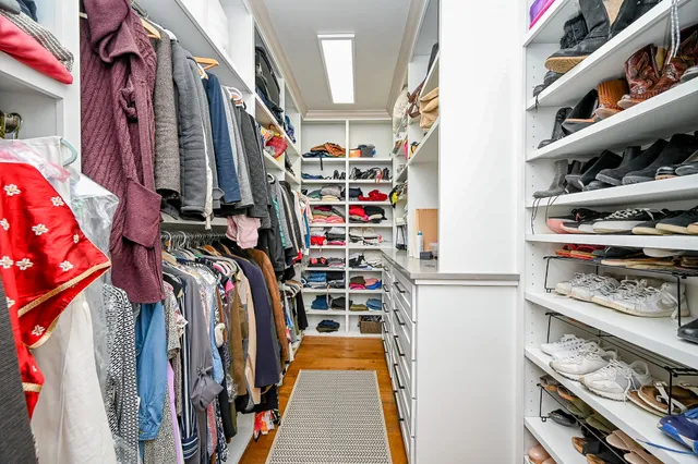 a view of walk in closet with clothes and shoes