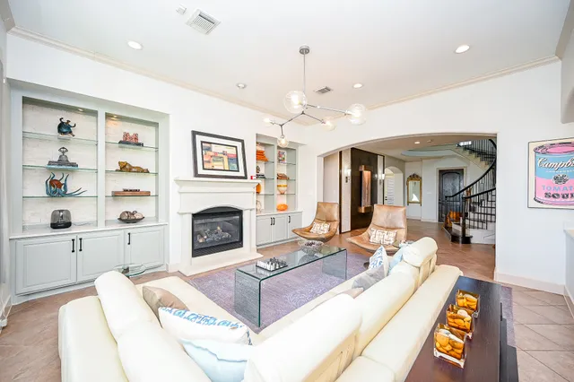 a living room with furniture a fireplace and a chandelier