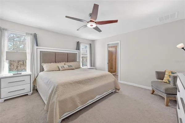 a bathroom with a granite countertop sink a toilet a large mirror and shower