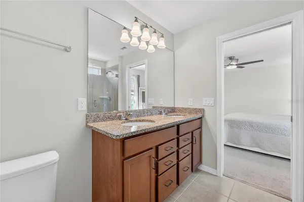 a bathroom with a granite countertop sink a toilet and a mirror