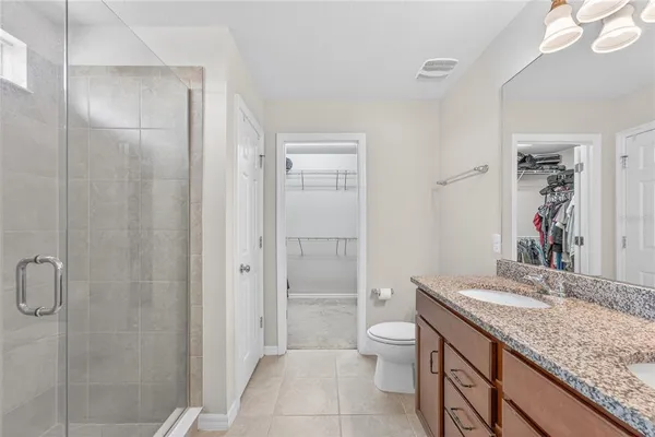 a bedroom with a large bed and a chandelier