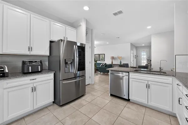 a kitchen with stainless steel appliances a refrigerator sink and cabinets