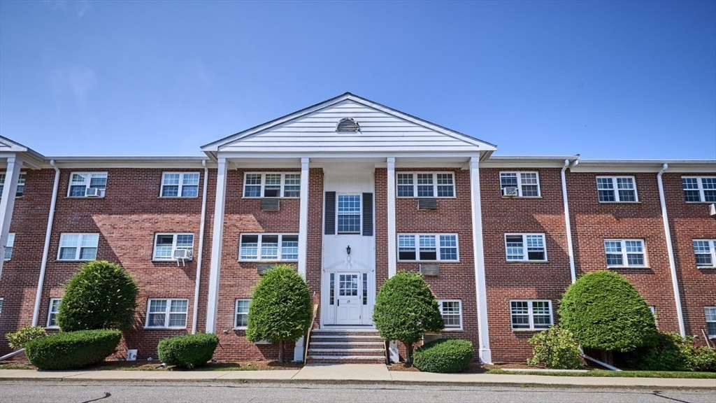 15 Old Colony Lane, Unit 7 Arlington, MA 02476 - Photo 12 of 12 a front view of a residential apartment building with a yard