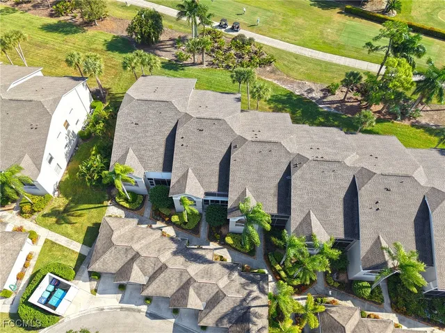 an aerial view of a residential apartment building with swimming pool and lawn chairs