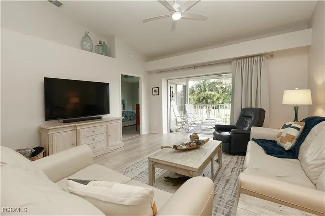 a living room with furniture a large window and a flat screen tv